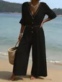 Chic black V-neck jumpsuit featuring lace trim detail presented in a scenic beach setting - Black