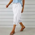 Detail of white cotton linen cropped pants featuring hem buttons and side pockets - S / Bottoms / White