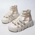 Close-up of white platform gladiator sandals with multi-strap design and chunky sole. - 35 / White