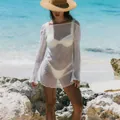 Detail of a white long-sleeve knitted beach cover-up with sheer crochet texture and ruffles - S / Dresses / White