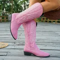 Detail view of pink suede cowboy boots with white embroidery in outdoor setting - 36 / Pink