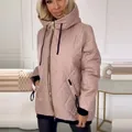 Detail of women's hooded quilted jacket in beige with black zipper and cuffs. - S / Tops / Pink