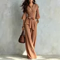 Full length detail of a French deep V brown jumpsuit with waist belt and wide leg pants. - S / Set / Tan