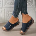 Close-up of blue peep-toe wedge sandals with thick platform soles and white stitching. - 36 / Navy Blue