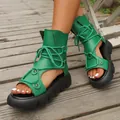 Detailaufnahme der grünen Gladiator-Sandalen zum Schnüren mit dicker schwarzer Plateausohle. - Grün