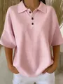 Close-up detail of the waffle-knit texture and button placket on a pink women's polo T-shirt. - Pink