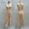Détail d'une robe longue jaune sans manches à col en V avec imprimé fleuri sur l'ourlet - S / Robe sans manches / Jaune