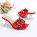 Detail van rode slippers met strassteentjes en transparante kristallen hak. - Rood