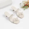 Elegantes sandalias beige de punta cuadrada con tacón bajo y correas con lazo. - Blanco Roto