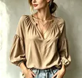 Detailansicht einer plissierten V-Ausschnitt-Bluse mit Ballonärmeln in Beigeton - S / Oberteile / Khaki