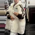 Detail view of women's loose white hooded fuzzy jacket with brown sleeve stripes - White Brown