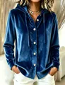 Gros plan d'un cardigan à capuche en velours bleu avec des boutons blancs et doux. - Bleu marine
