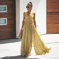 Gelbes geblümtes Boho-Maxikleid mit V-Ausschnitt und hohem Schlitz am Model im Freien - S / Kleider / Gelb