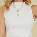 Close-up detail of white sleeveless ribbed knit tank top featuring a ruffled high neck. - S / Tops / White