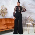 Close-up detail of black sequined lace top with sheer mesh sleeves and wide-leg trousers - S / Jumpsuits / Black
