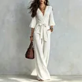 Lifestyle shot of white puff sleeve jumpsuit with waist bow belt and brown woven bag - S / Set / White
