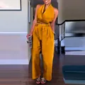 Detailansicht eines stylischen senfgelben Neckholder-Tops und einer weiten Hose. - Gelb