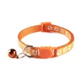 Close-up van een oranje kattenhalsband met witte pootafdrukken en een metalen bel. - Kattenkop Gesp Stijl / Oranje