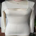 Dettaglio con la scollatura irregolare cut-out e la trama a coste del top aderente - Taglia S / Top / Bianco avorio