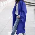 Stylish royal blue oversized wool coat for women over a grey sweater on an outdoor walkway. - Royal Blue