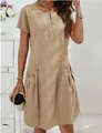 Close-up view of a beige cotton linen dress with zipper neckline and decorative side pockets - Apricot