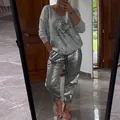 Detailed view of women's two-piece set featuring silver metallic pants and printed top - Top And Bottom / Gray / S