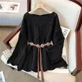 Detalle en primer plano de jersey negro de punto calado con un cinturón marrón. - Talla única / Tops / Negro (Con Cinturón)