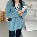 Dettaglio di un cardigan a maglia azzurro oversize con scollo a V e grandi tasche - Taglia unica / Top / Blu