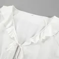 Macro view of a white cotton linen V-neck blouse featuring elegant ruffle details and a tie-front. - S / Top And Bottom / White