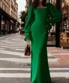 Elegant emerald green long sleeve U-neck mermaid maxi evening gown in an urban street setting - Green