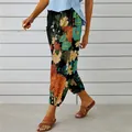 Detailed view of floral cotton linen pants with drawstring waist and ankle buttons. - S / Black