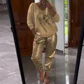 Detailed view of women's gold two-piece set featuring long sleeve top with eye graphic - Brown