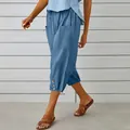 Detail view of blue cotton-linen cropped pants with drawstring waist and buttoned hem - Denim Blue