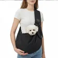 Black quilted pet sling carrier for small dogs shown in use with a small white puppy - Black