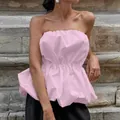 Detailed view of a pink strapless top with a smocked waist and puffy peplum design. - S / Tops / Pink