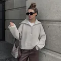 Fashion model wearing an oversized beige quarter-zip knit sweater with V-neck collar - S / Tops / Gray