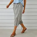 Detailed side view of grey cotton linen cropped pants featuring decorative buttons on the hem - Light Gray