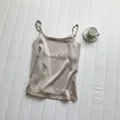 Detailed macro view of champagne satin camisole with minimalist thin shoulder straps - M / Tops / Apricot
