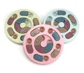 Detailansicht von drei bunten interaktiven Puzzle-Slow-Feeder-Hundenäpfen mit Futter - Rund / Kartonverpackung / Rosa