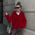 Model wearing a vibrant red oversized knit sweater with quarter-zip lapel detail - S / Tops / Burgundy