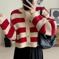 Close-up of a red and white striped knit cardigan with luxury gold buttons for women. - One Size / Tops / Red