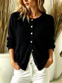 Close-up of an elegant black knit cardigan featuring metallic gold buttons and long sleeves - S / Tops / Black