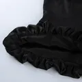 Close-up detail of the ruffled hem and glossy texture of a black satin sleeveless camisole top - S / Tops / Black