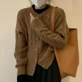Detail view of a cozy brown cable-knit crewneck cardigan with loose long sleeves. - One Size / Tops / Brown