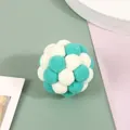 Close-up of a teal and white plush pompom ball toy for cats on a pastel background - Green And White
