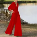 Close-up detail of stylish red wide-leg jumpsuit featuring V-neck and flared sleeves - S / Red