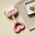 Close-up detail of a pink plush squeaky dog toy featuring a heart-shaped rubber teether handle - Pink Pig Style