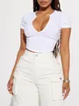 Detailed view of a white slim fit crop top featuring a deep V-neck and ribbed corset style seams - S / Tops / White