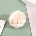 Close-up detail of soft plush pom-pom cat toy ball in soft pink and white colors - Beige