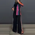 Detailed view showing the colorful striped blazer and side-stripe wide-leg pants set. - Black and Blue Striped